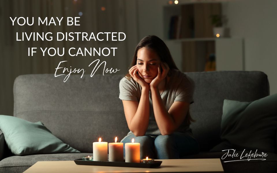 You May Be Living Distracted if You Cannot Enjoy Now | woman sitting on couch with chin on hands, looking at three lit candles on coffee table