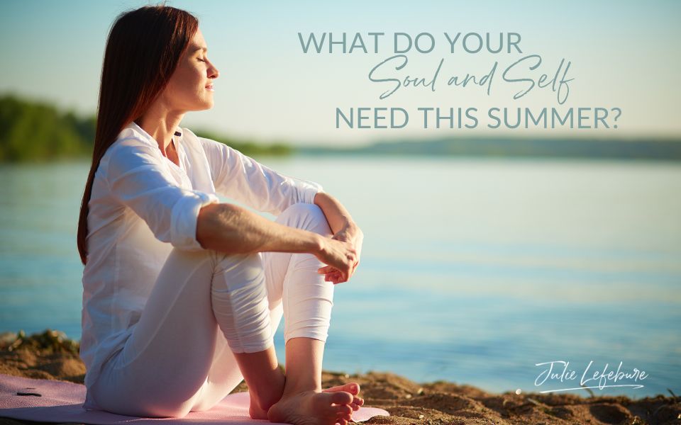 What Do Your Soul and Self Need This Summer? | woman sitting on a beach in white clothing, with arms over bent knees facing the sun